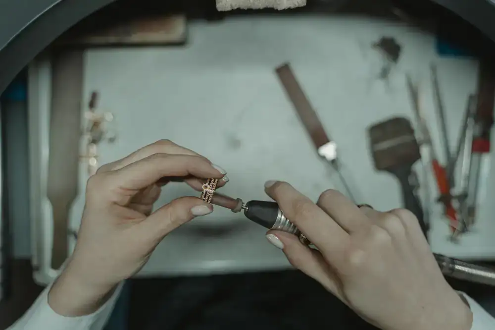 Close up of a silversmith crafting a custom metal ring at a workbench
