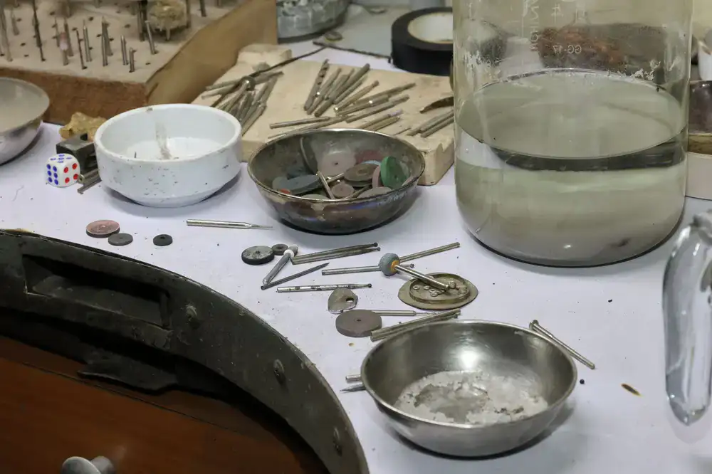 Silversmith tools arranged neatly on a wooden workbench
