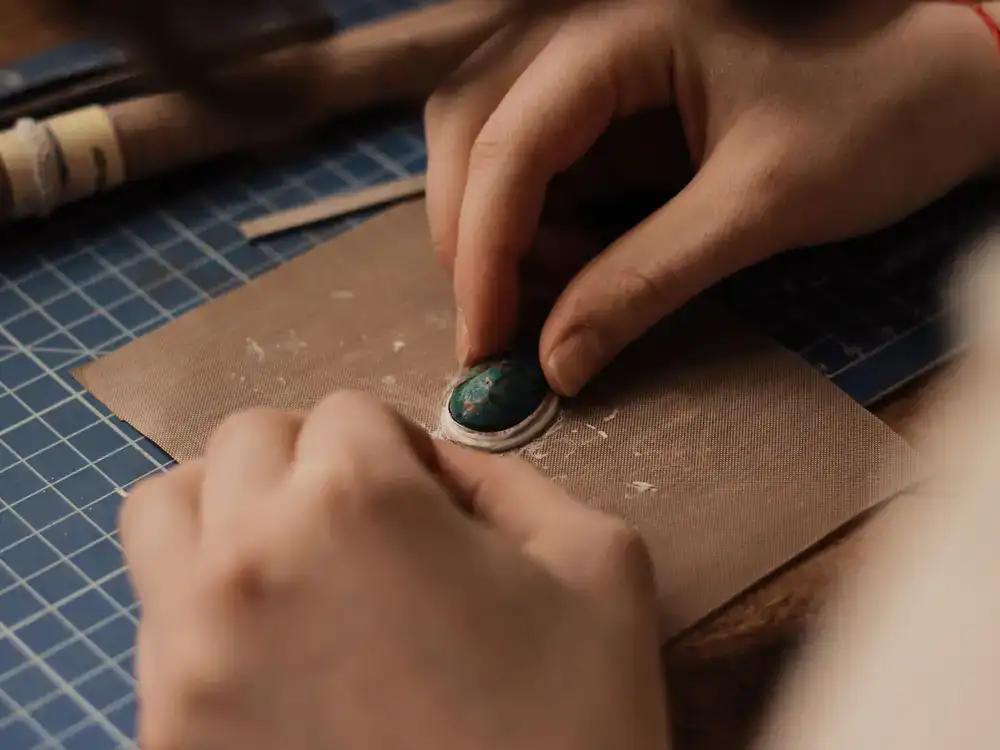 Silversmith meticulously polishing a custom silver piece at the workbench