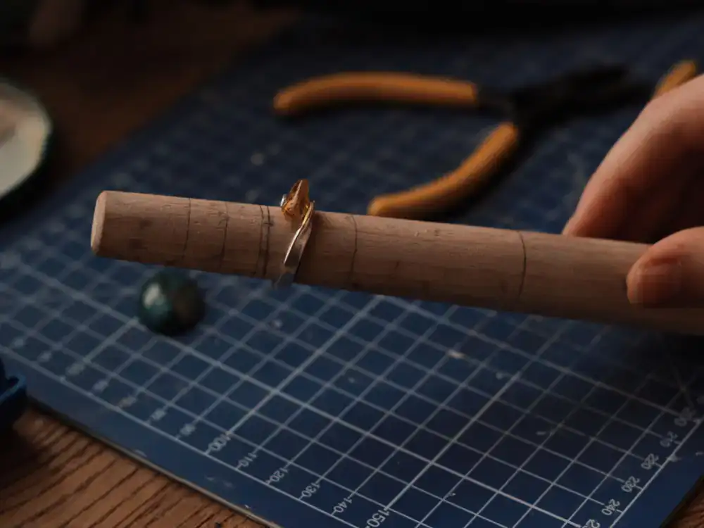 Hands measuring a ring size on a mandrel